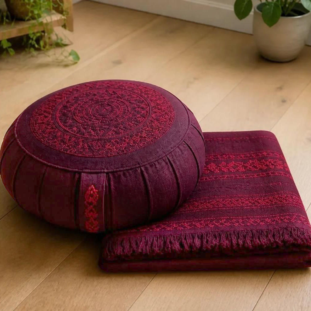 Sur un parquet, un coussin et un tapis de méditation